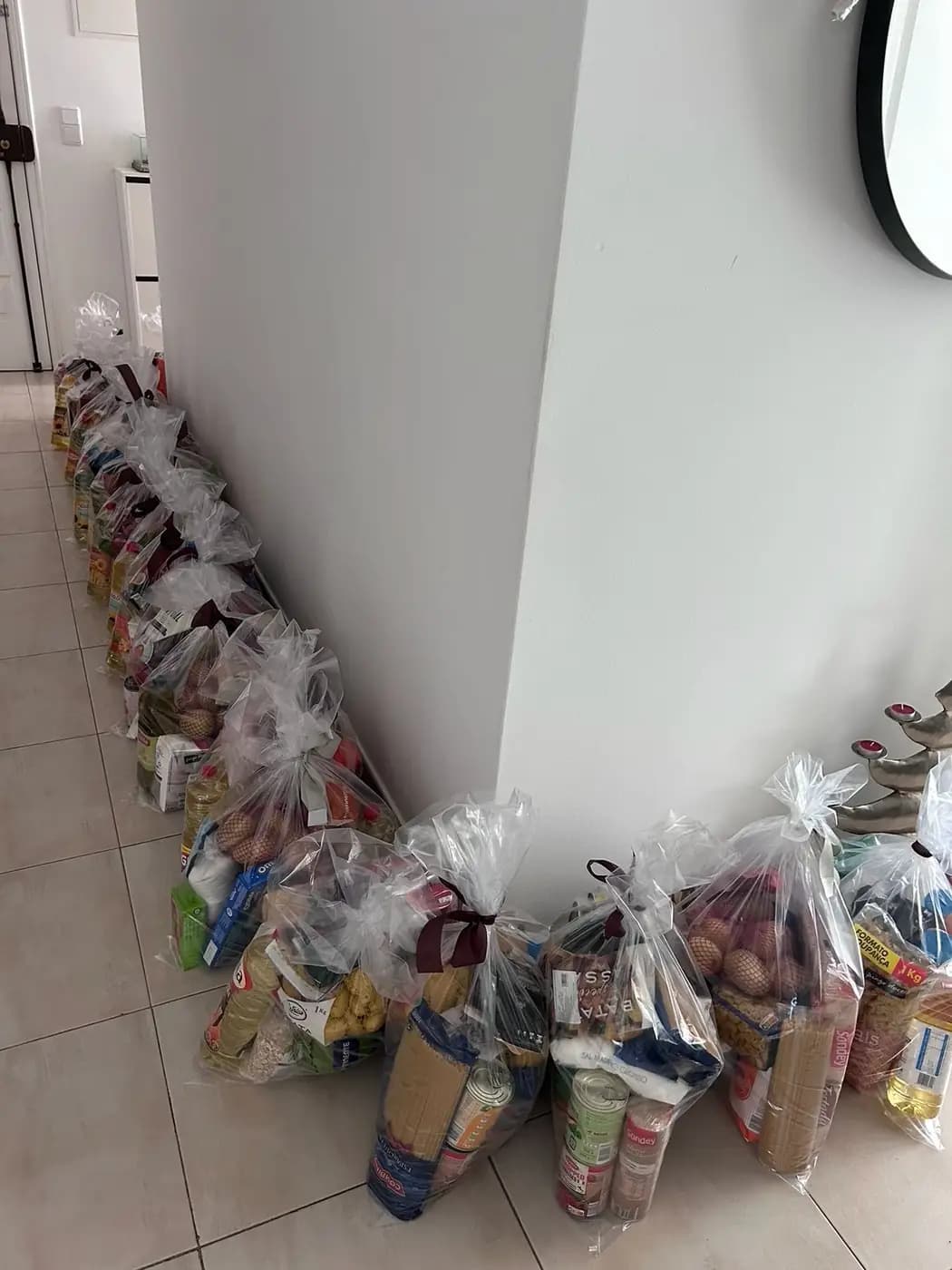 Fila de cabazes embalados encostada à parede, prontos a sair