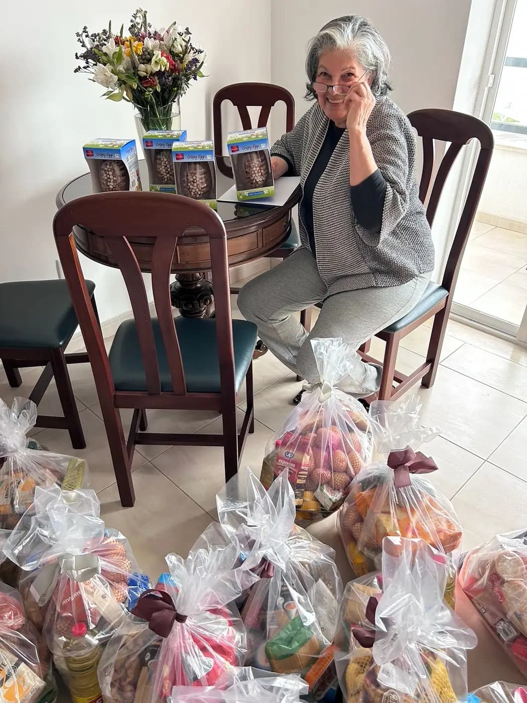 Voluntária sentada junto aos cabazes preparados na sede