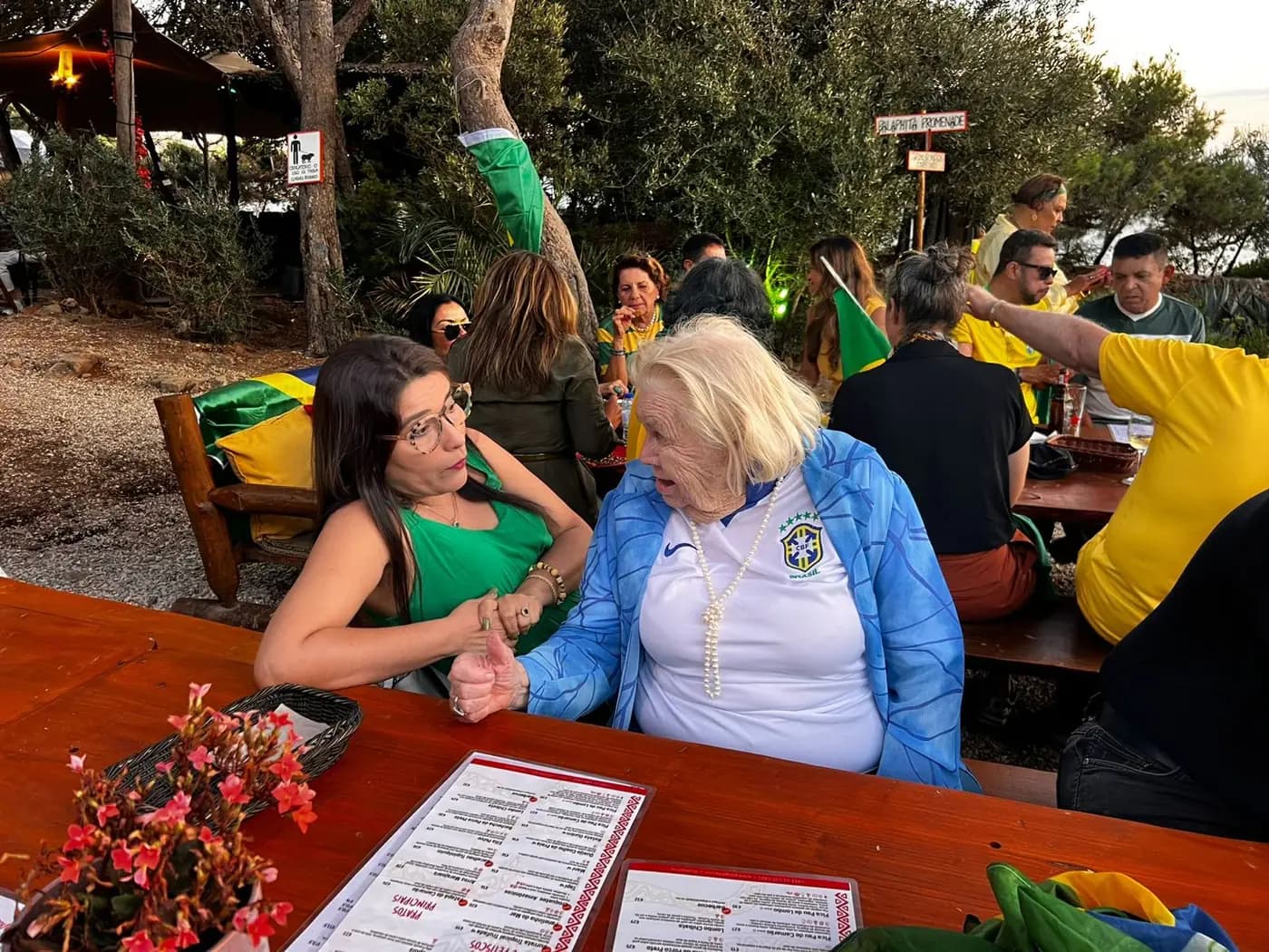 Convivas à mesa comprida, entre decoração verde e amarela