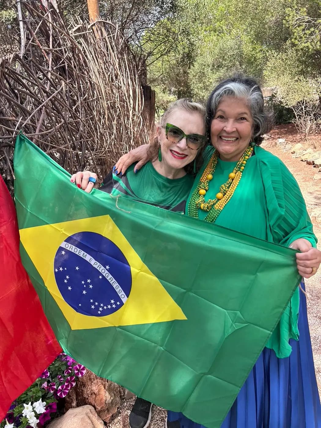 Duas associadas seguram a bandeira do Brasil aberta
