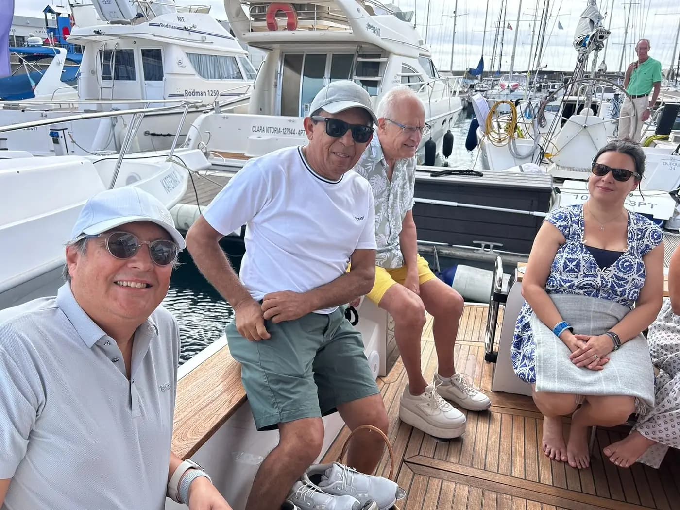 Participantes sentados no deque, com a embarcação ainda atracada