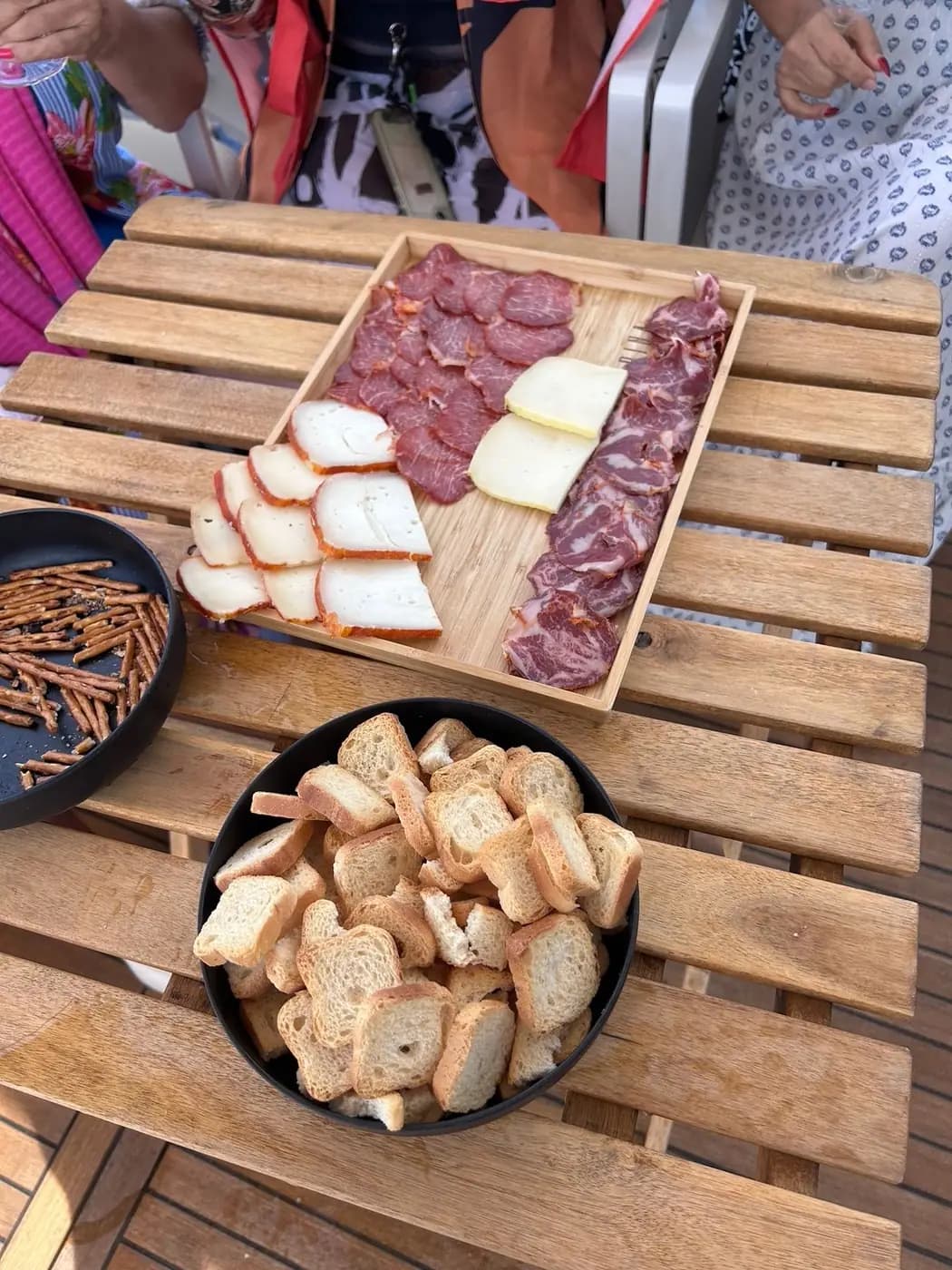 Tábua de queijos, enchidos e pão servida a bordo