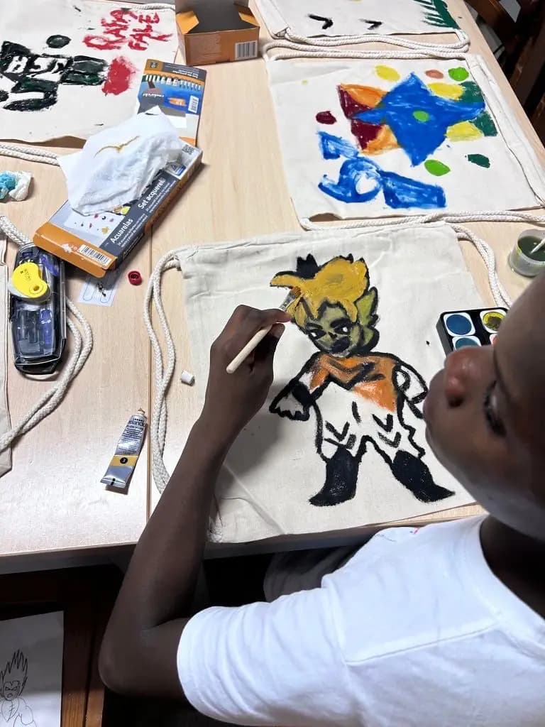 Criança pinta um desenho de super-herói na sua mochila