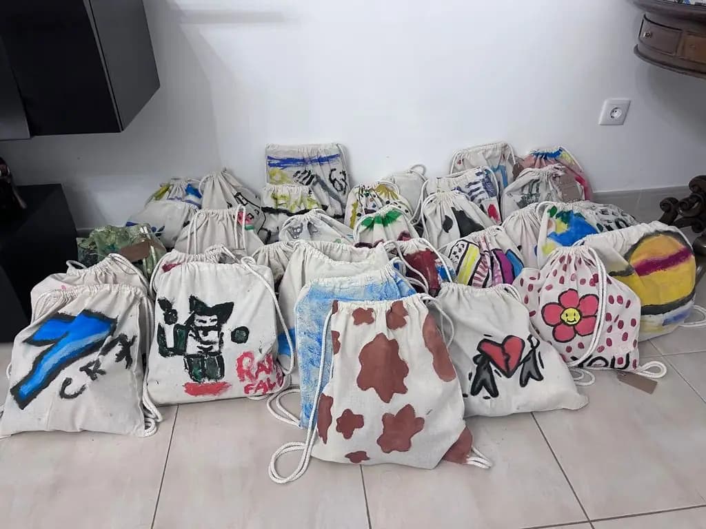 Mochilas pintadas a secar, encostadas à parede da sala