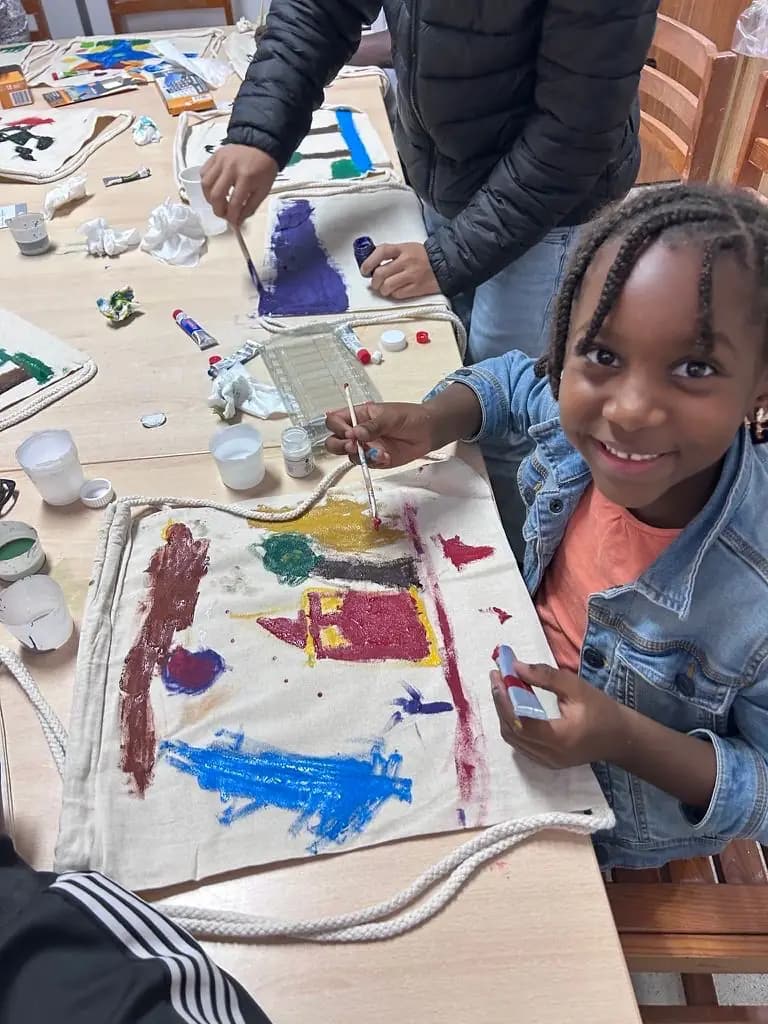 Criança sorri durante a atividade de pintura